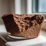 Close-up view showing the airy, rich texture of a serving of chocolate mousse in a glass dish.
