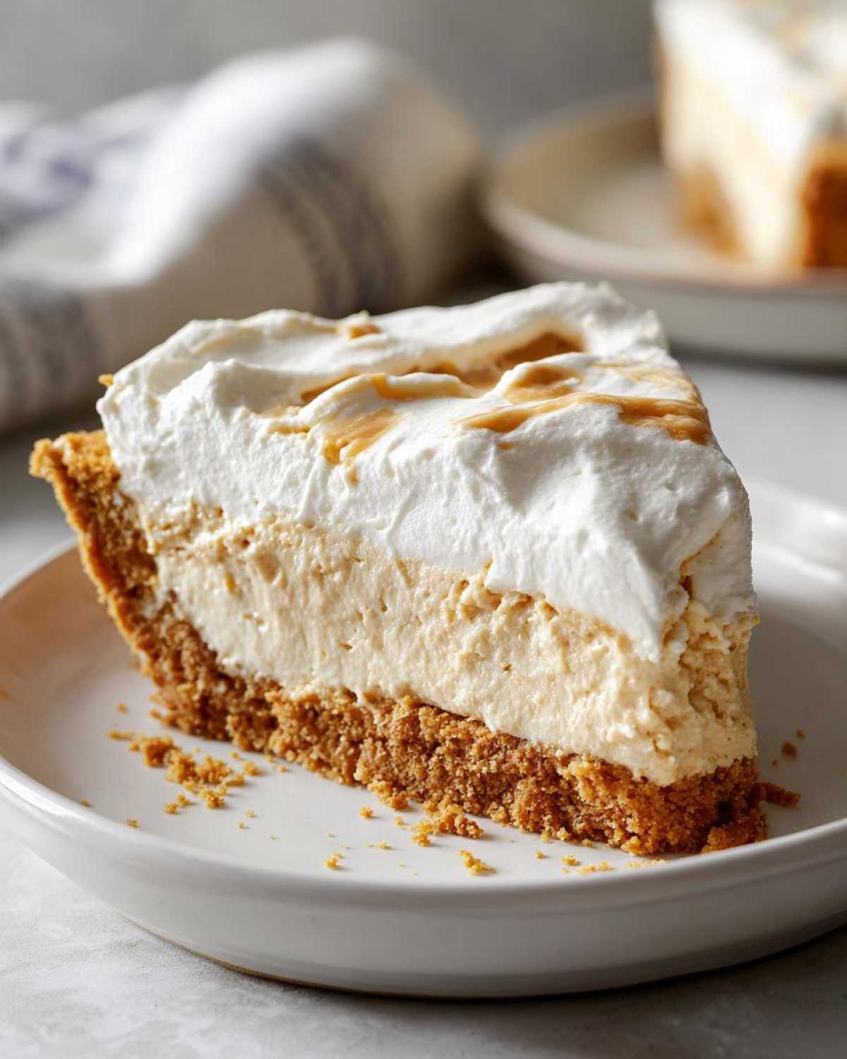 Close-up of a slice of 400 calorie peanut butter pie featuring a graham cracker crust, creamy filling, and whipped topping.