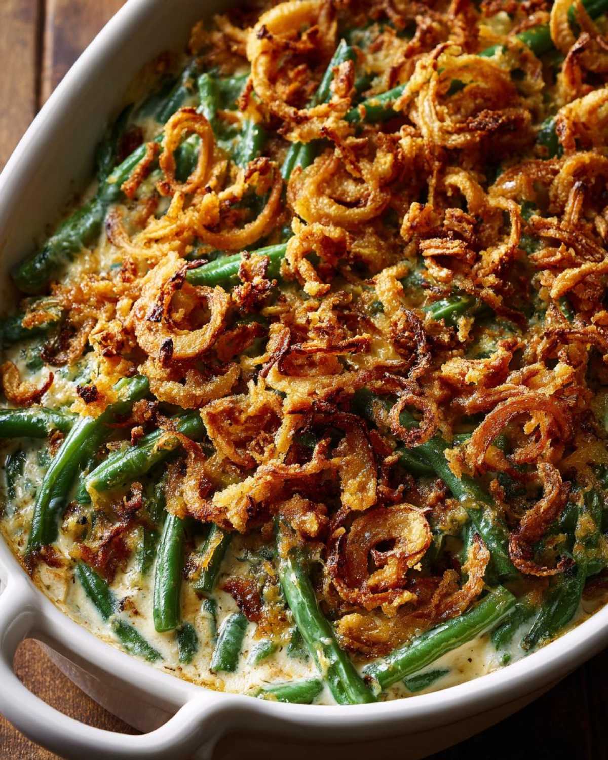 Close-up of a creamy green bean casserole topped generously with crispy fried onions.