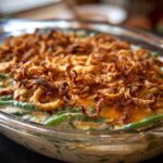 Close-up of a creamy green bean casserole topped generously with crispy fried onions.