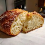 Cross-section of amazing Italian bread showing a golden, crisp crust and an open, airy crumb structure.