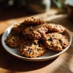 A stack of freshly baked oatmeal cookie treats with chocolate chips, bathed in sunlight.