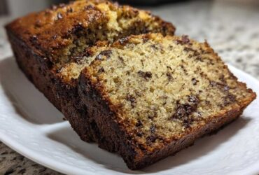 Close-up of sliced chocolate chip vegan banana bread showing a moist crumb and dark crust.