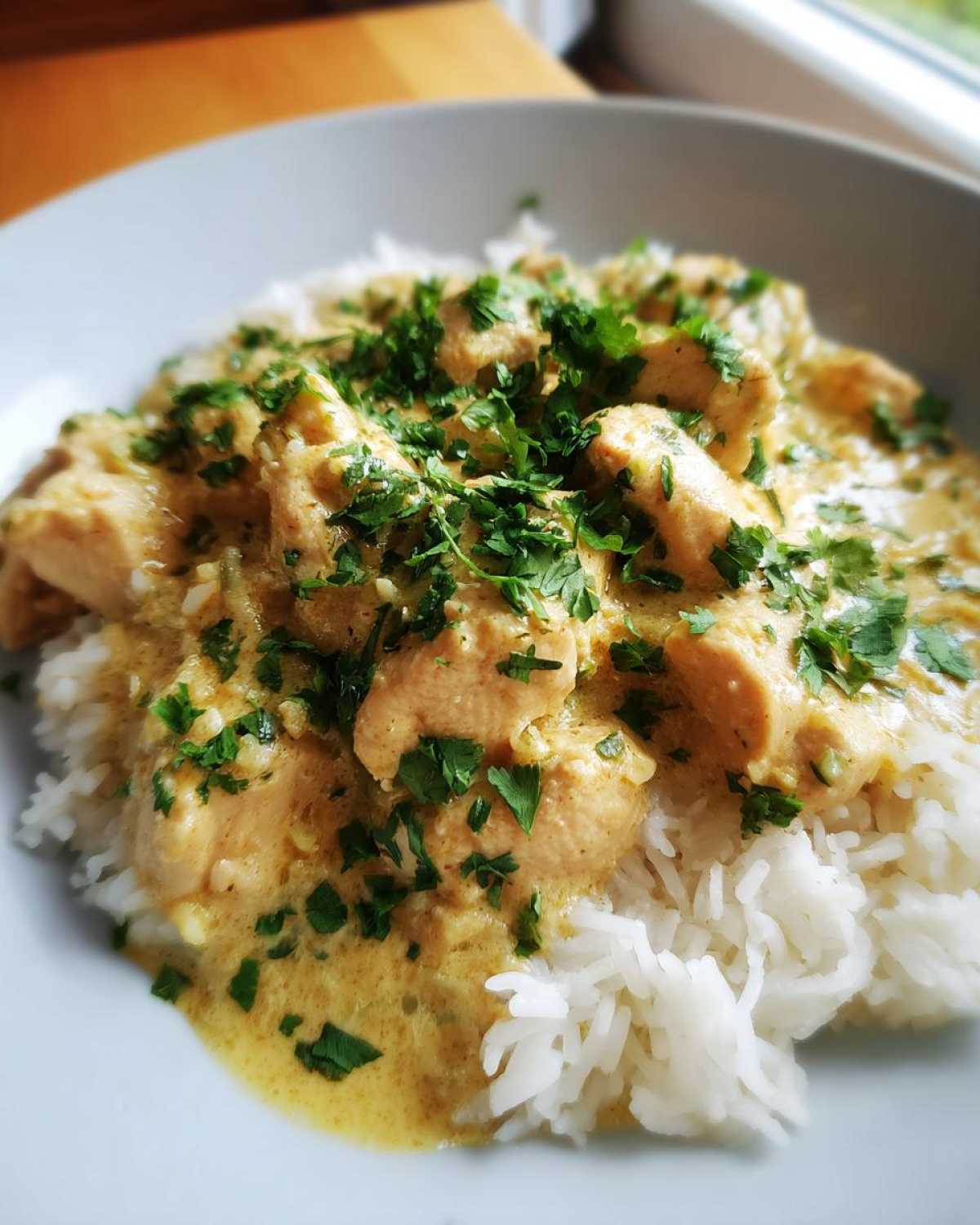 Close-up of creamy coconut lime chicken served over fluffy white rice and garnished with fresh parsley.
