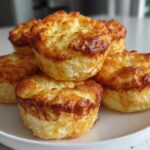 A stack of five golden-brown cottage cheese egg cups starbucks hack muffins piled on a white plate.