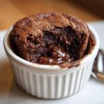 Close-up of a warm Cottage Cheese Microwave Brownie with a molten chocolate center in a white ramekin.