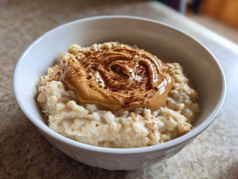 Close-up of creamy banana oatmeal topped with a swirl of peanut butter and a sprinkle of cinnamon.
