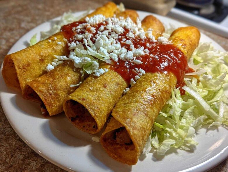 Four crispy, rolled potato tacos smothered in red salsa and crumbled white cheese, served on shredded lettuce.