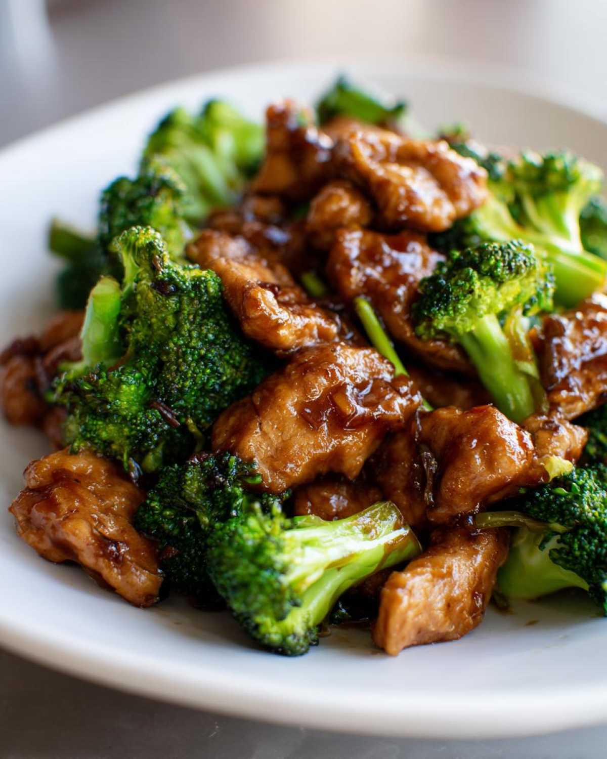 Close-up of tender pieces of chicken and bright green broccoli florets coated in a savory brown sauce, perfect for chicken and broccoli.