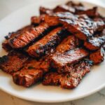 Close-up of sliced, grilled carne asada steak showing a juicy interior, prepared with the best carne asada marinade.