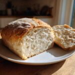 Close-up of a loaf of homemade whole wheat bread, sliced to show the airy interior crumb.
