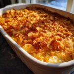 Close-up of a baked hot chicken salad casserole with a crispy, golden cornflake topping.