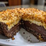 A slice removed from a no-bake german chocolate pie showing rich chocolate filling and toasted coconut topping.