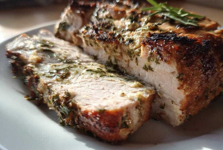Close-up of a moist, sliced slow cooker turkey breast seasoned with herbs and having a browned exterior.