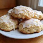 A stack of soft, freshly baked ricotta cookies topped with a sweet white lemon glaze.