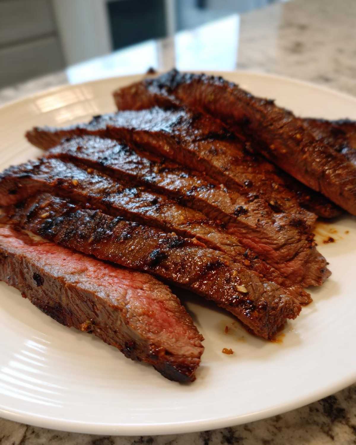 Close-up of medium-rare steak slices showing char marks, prepared with carne asada marinade.