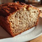 Close-up of a slice of moist sugar free banana bread showing its texture and dark golden crust.
