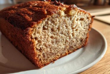 Close-up of a slice of moist sugar free banana bread showing its texture and dark golden crust.