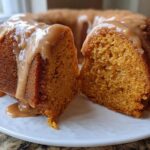 Close-up of a slice cut from a sweet potato pound cake, covered in a thick caramel-colored glaze.
