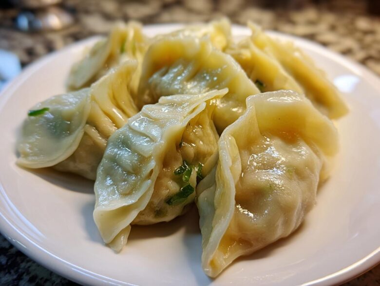 Close-up of freshly steamed Traditional Chinese Dumplings piled on a white plate, showing moist wrappers and green scallion filling.
