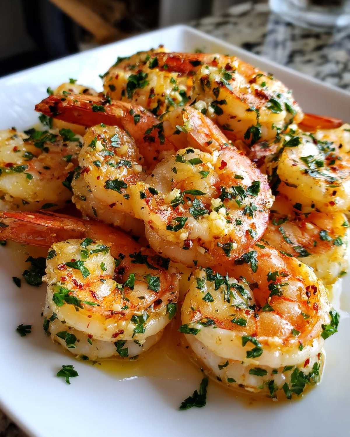 Close-up of juicy Air Fryer Crispy Garlic Butter Shrimp coated in butter, garlic, and fresh parsley.