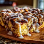 Close-up of freshly baked Banana Bread Batter Cinnamon Buns covered in thick white icing.