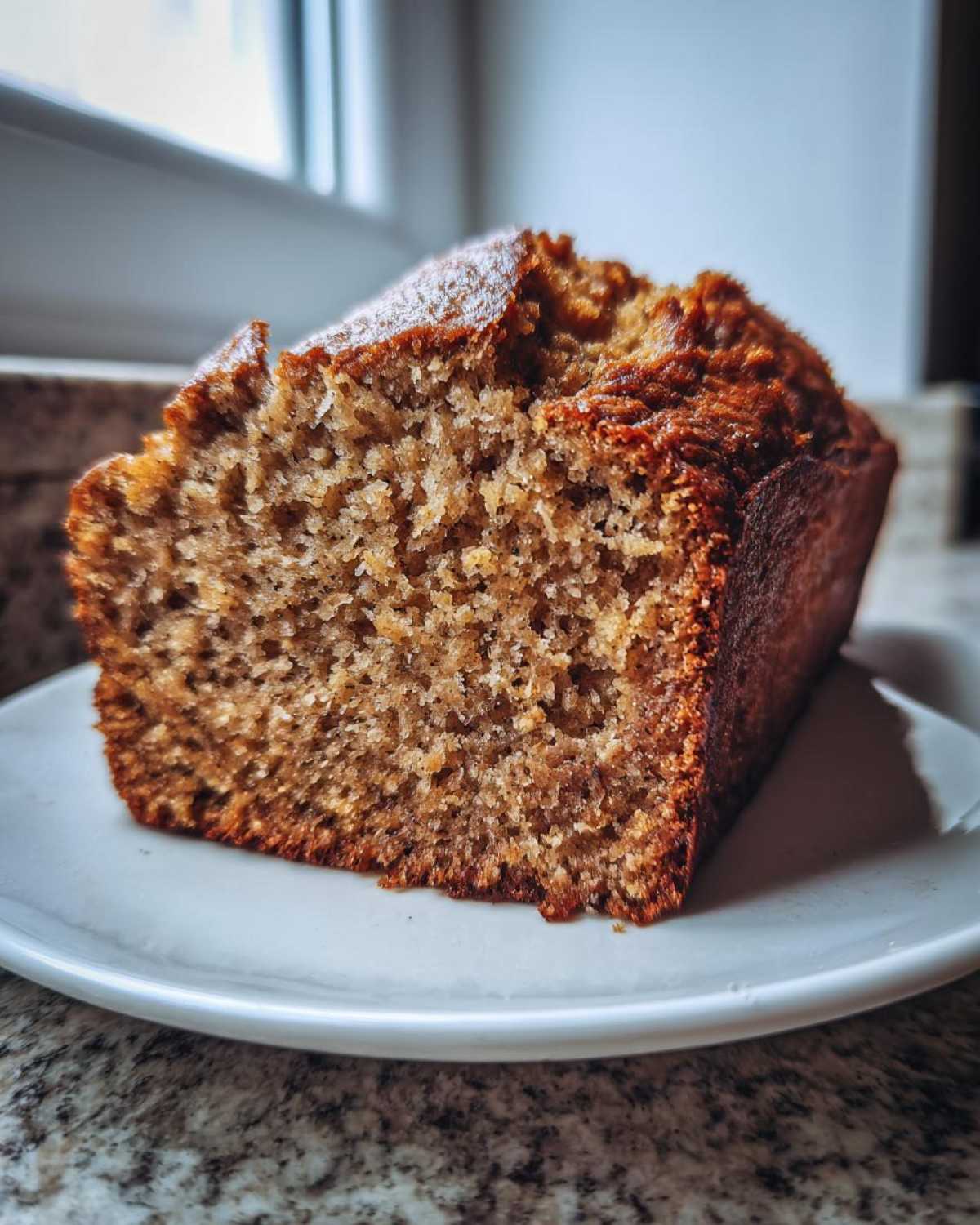 Close-up of a thick slice of moist banana bread showing its crumb texture, part of The Banana Bread Step by Step.