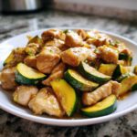 A close-up of tender chicken pieces mixed with bright green zucchini slices coated in a savory sauce, ready to eat chicken zucchini stir fry.