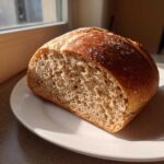 A close-up of a freshly sliced loaf showing the crumb structure of the Copycat Dark Brown Honey Wheat Bread.