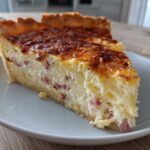 A thick slice of Cottage Cheese Quiche with visible ham pieces, resting on a white plate.