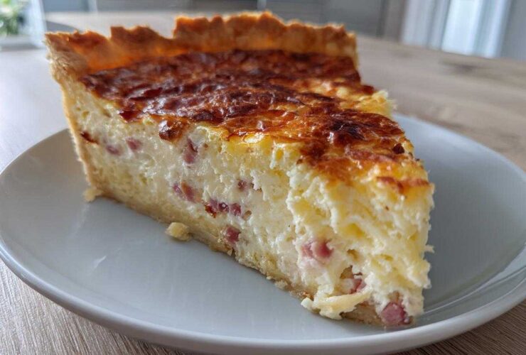 A thick slice of Cottage Cheese Quiche with visible ham pieces, resting on a white plate.