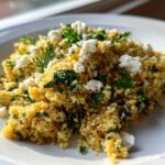 A close-up of Easy One-Pot Creamy Lemon Herb Couscous topped with crumbled feta cheese and fresh parsley.