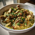 Close-up of seared chicken pieces coated in a creamy green salsa verde sauce, garnished with fresh cilantro.