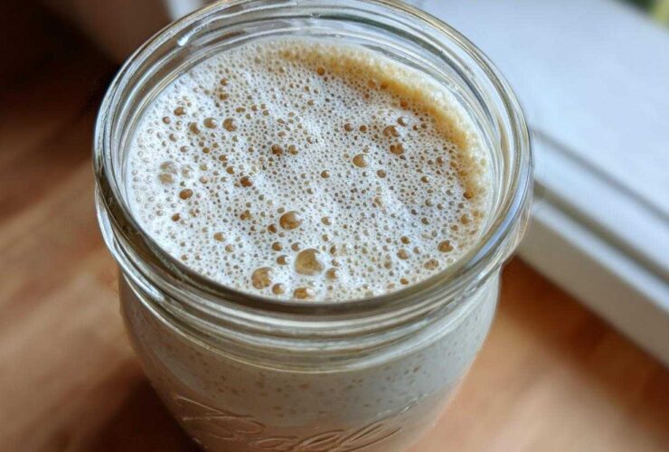 Overhead view of creamy chia seed pudding topped with a layer of light brown foam in a glass Ball jar.