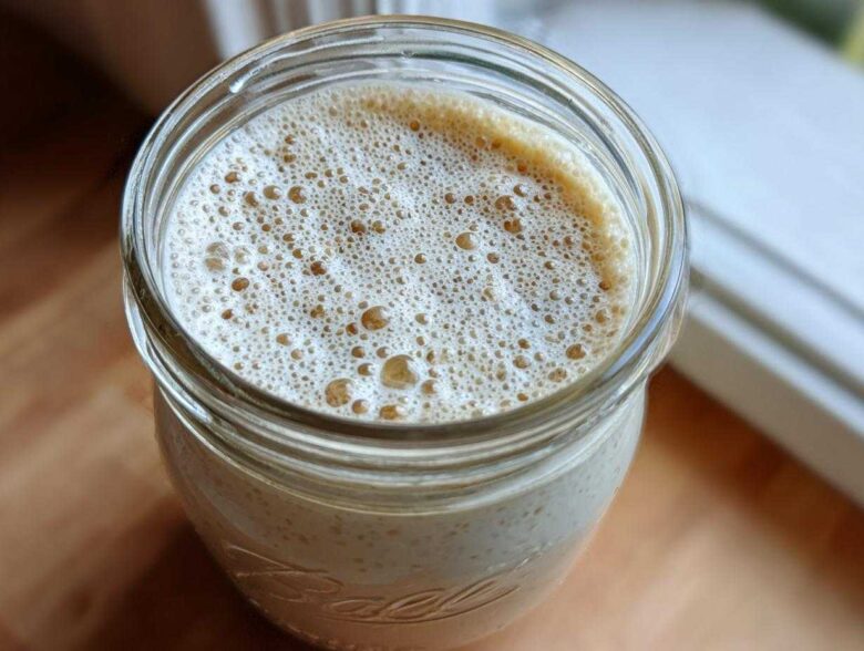 Overhead view of creamy chia seed pudding topped with a layer of light brown foam in a glass Ball jar.