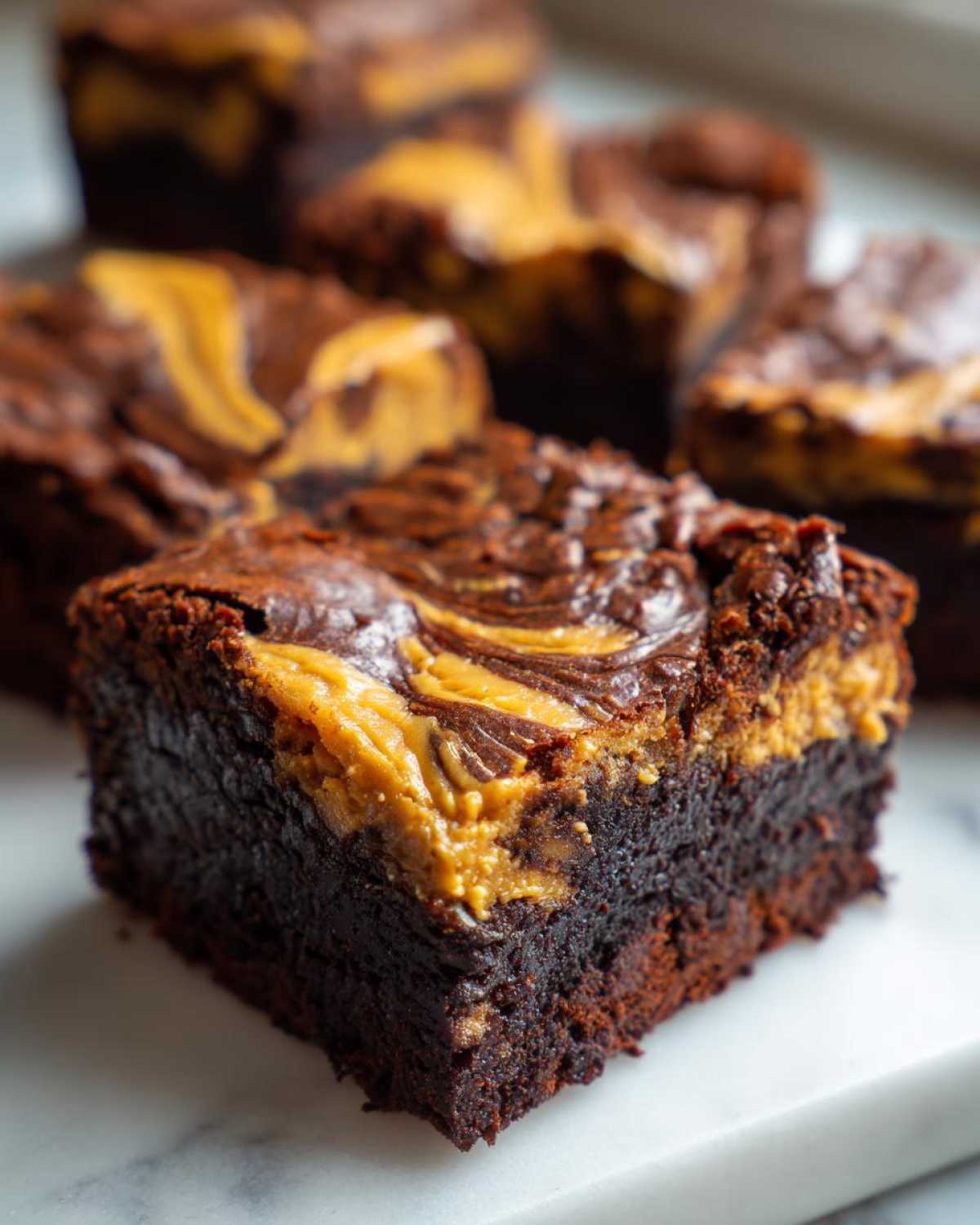 A close-up of a rich, fudgy Gluten-Free Chocolate Peanut Butter Swirl Brownies square with a visible swirl pattern on top.