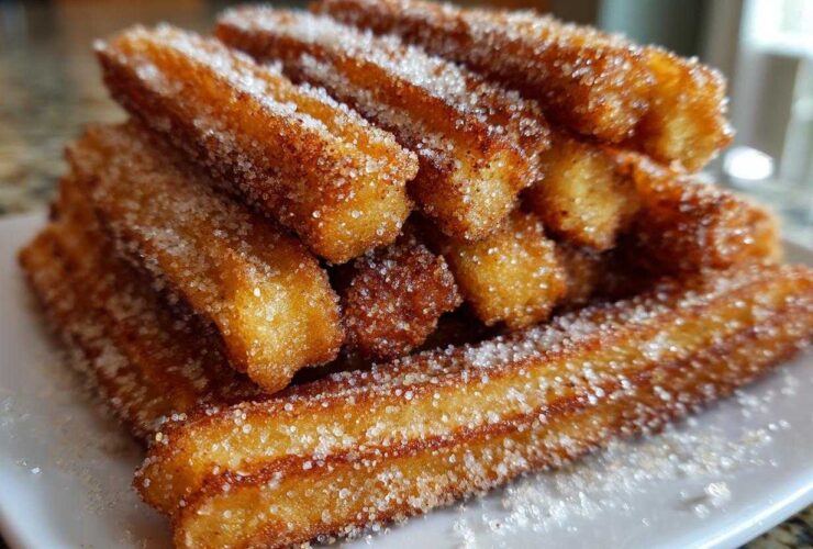A close-up stack of golden brown Gluten-Free Cinnamon Sugar Waffle Sticks heavily coated in sparkling sugar.