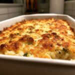 Close-up of The Homemade Broccoli Cheese Rice Casserole with a bubbly, golden-brown cheese topping.