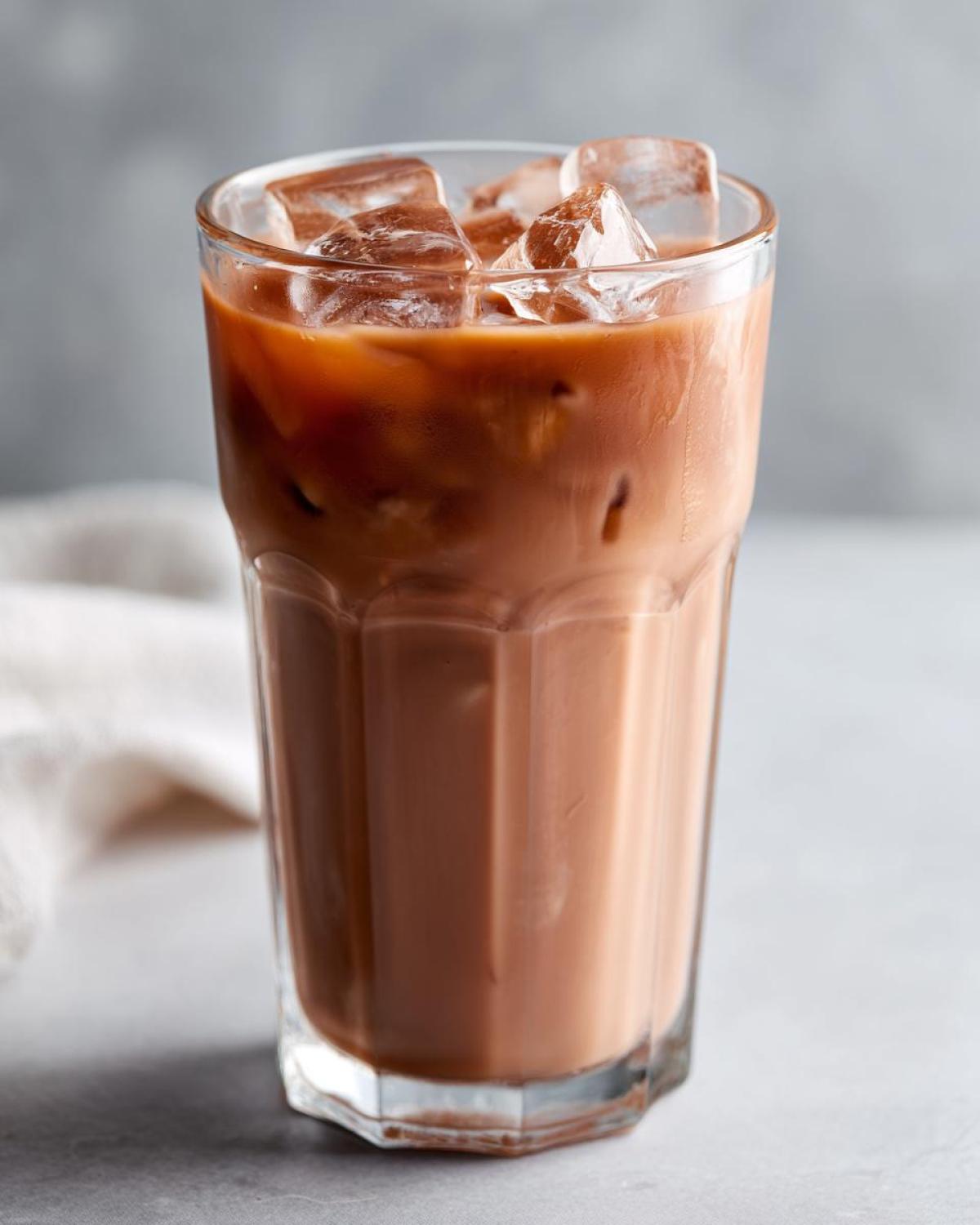 Close-up of a tall glass filled with Iced Raspberry Vanilla Chai, topped with ice cubes.