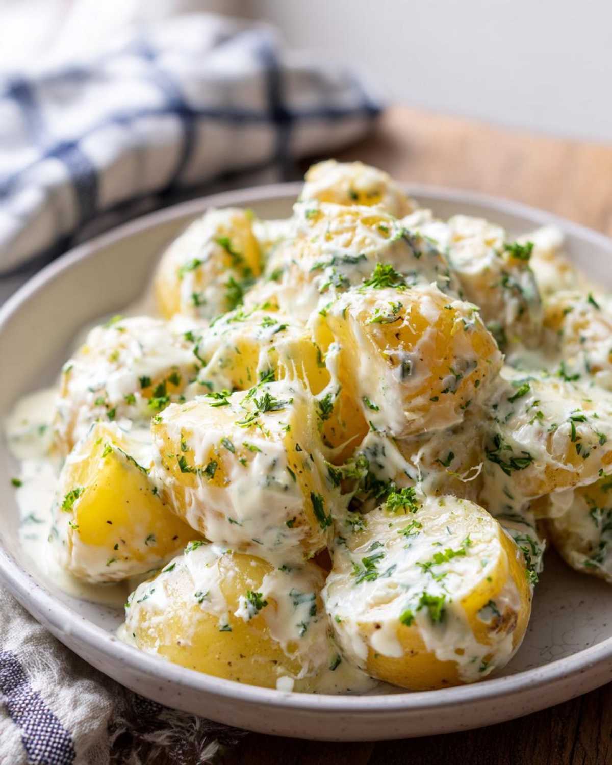 A close-up of Instant Pot Creamy Garlic Butter Potatoes coated in a rich, white sauce and sprinkled with fresh parsley.