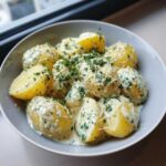 A close-up of Instant Pot Creamy Garlic Butter Potatoes coated in a rich sauce and topped with fresh parsley and grated cheese.