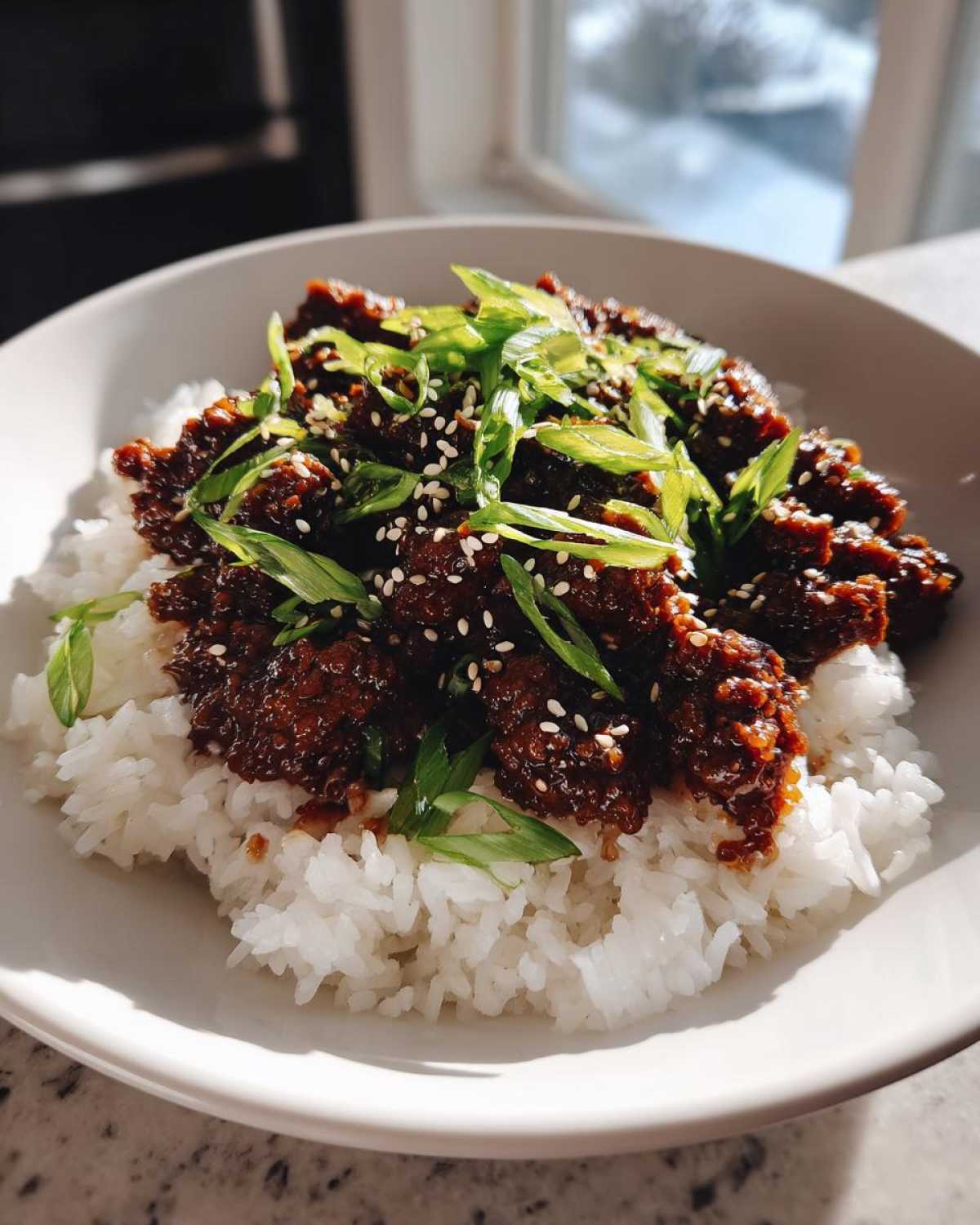 Close-up of Instant Pot Korean Beef and Rice Bowls topped with green onions and sesame seeds.