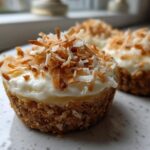 A close-up of one of the No-Bake Lemon Coconut Cheesecake Cups topped with toasted coconut flakes.