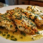 Four golden-brown fillets of One-Pan Creamy Garlic Butter Tilapia swimming in a rich, buttery garlic sauce and topped with fresh parsley.
