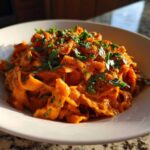Close-up of One-Pot Creamy Tomato Basil Tortilla Pasta, richly coated in sauce and topped with fresh basil.