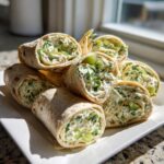 A stack of sliced Pickle Dip Pinwheels Favorite Blogger Recipes on a white plate.
