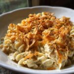 A creamy serving of Pioneer Woman Tuna Noodle Casserole topped generously with crispy fried onions.