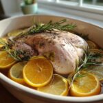 Raw turkey seasoned and submerged in liquid with orange and lemon slices for turkey brine.