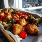 Close-up of crispy Sheet Pan Crispy Honey Mustard Tofu cubes mixed with roasted broccoli and red peppers.
