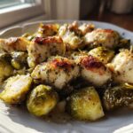 Close-up of Sheet Pan Garlic Butter Chicken and Brussels Sprouts served on a white plate.